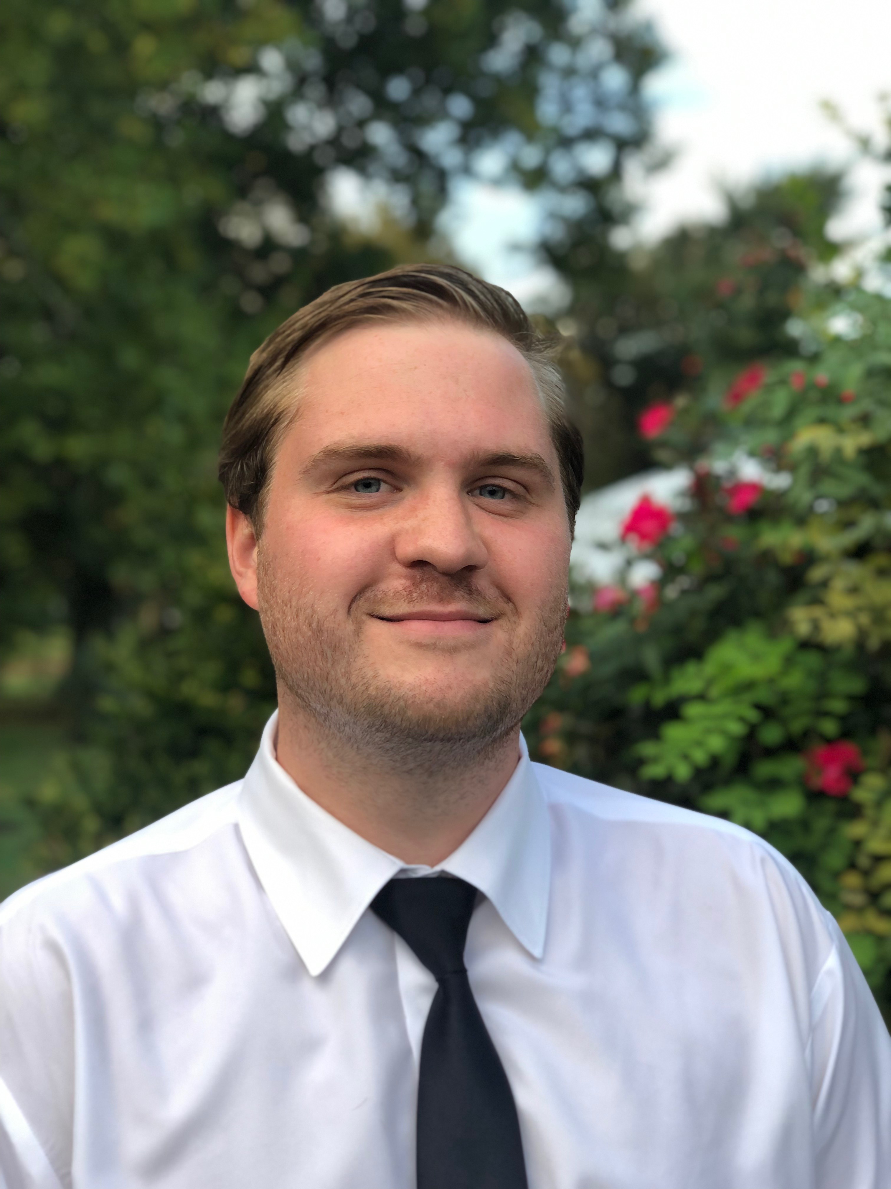 Portrait of Stephen in front of a rose bush